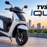 TVS iQube electric scooter parked outdoors showing premium design and LED lighting.